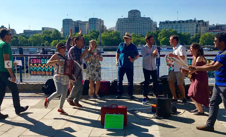 Talia busking with a business team in 2016